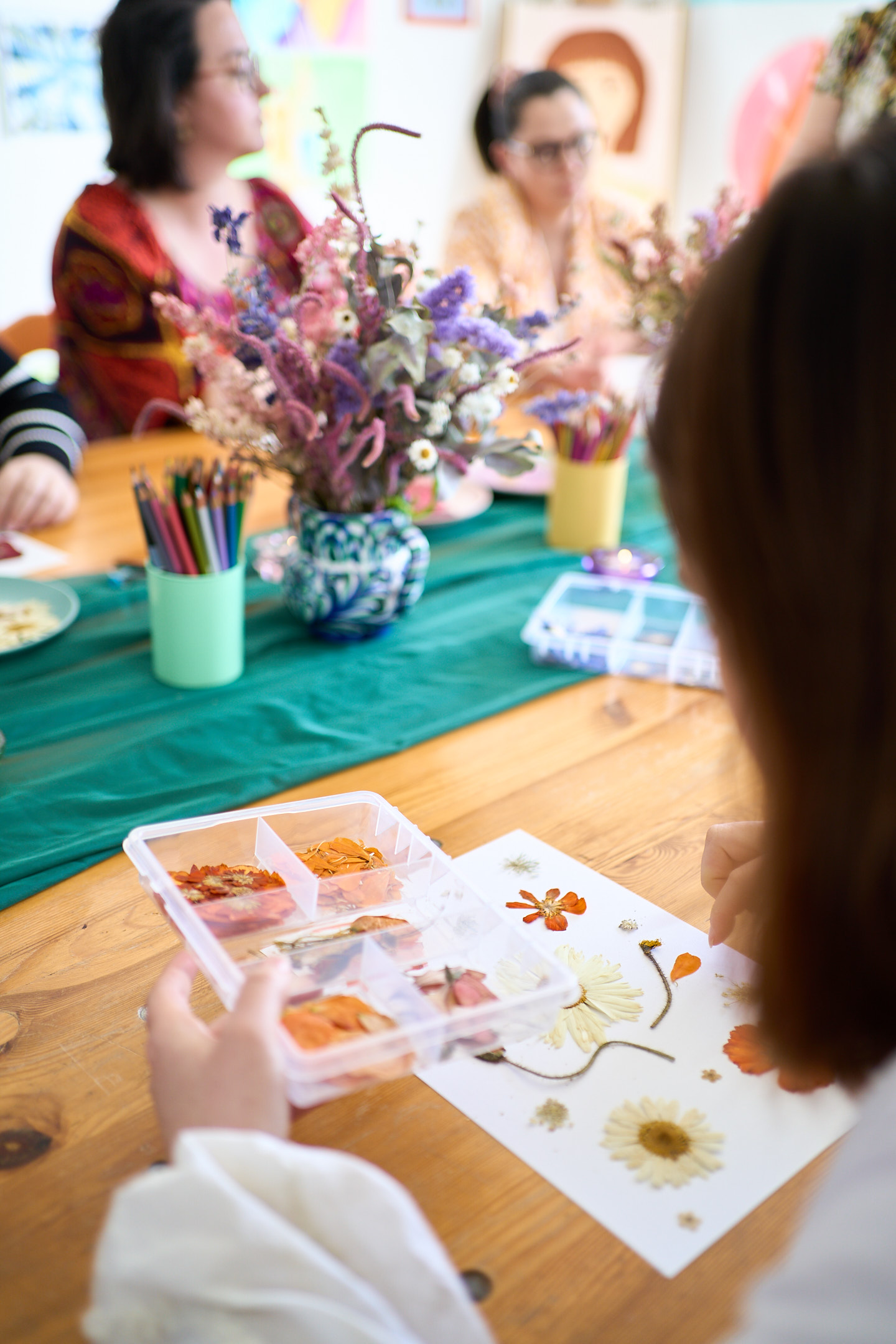 Participante à un atelier d'art symbolique et florale confectionnant une image fleurie
